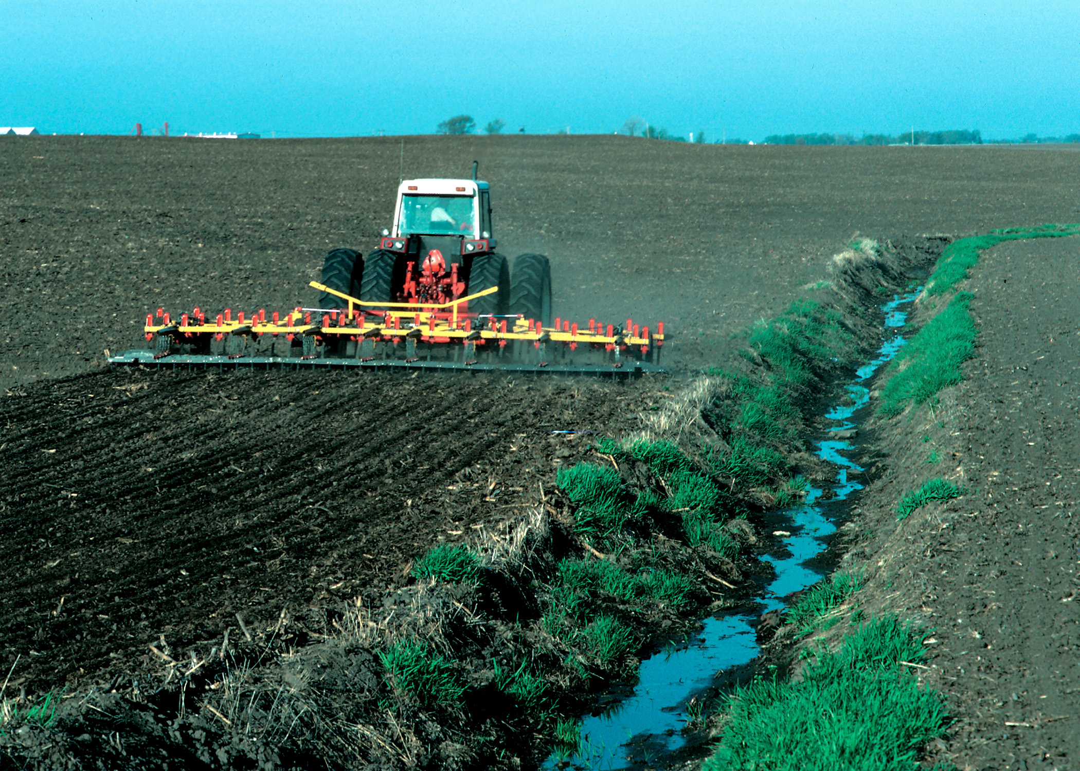 Contaminación del agua de origen agrícola como en la imagen del tractor echando fertilizantes en el suelo que pueden filtrarse hasta los acuíferos